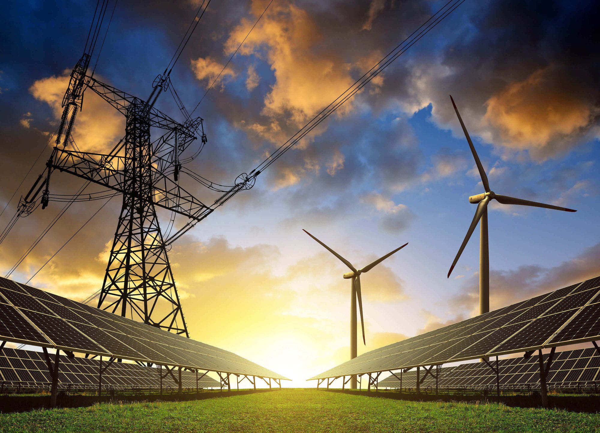 Solar panels, wind turbines, and electricity pylons at sunset. 