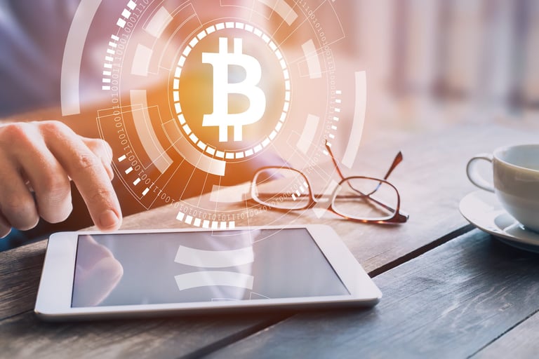 Hand pointing at tablet computer screen with Bitcoin logo floating above it