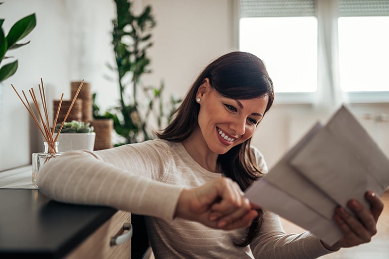 Hispanic Lady Opens Mail with Smile