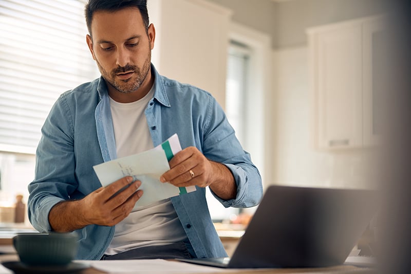 Man Opening Bill with Computer