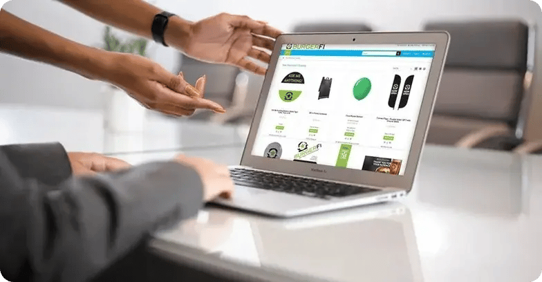 Two people looking at the BurgerFi storefront on a laptop computer