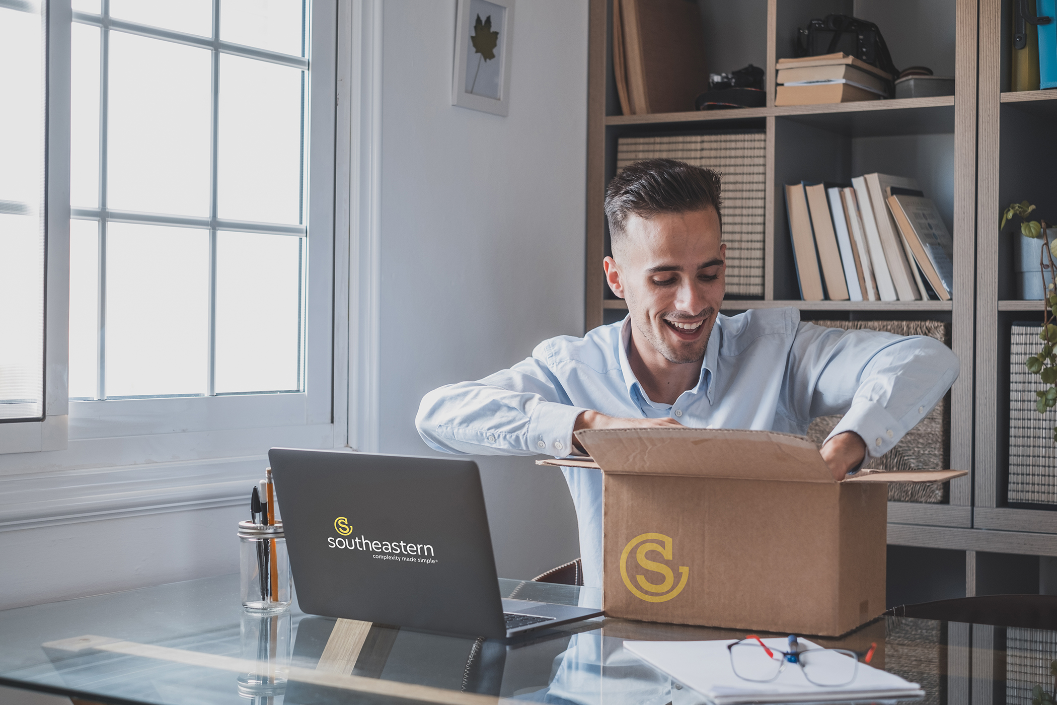 A new employee is delighted when he opens a package of branded corporate gifts from his new employer.